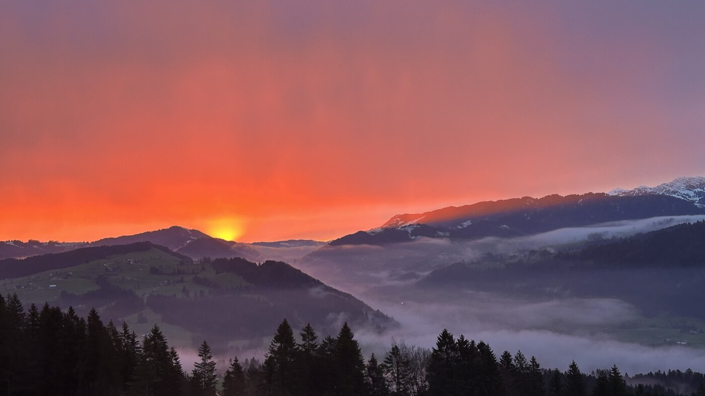 Sonnenaufgang über den Bergen bei Sulzberg im Bregenzerwald, Nebel im Tal